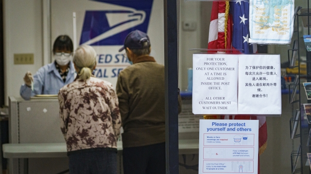 Customers speak with an Post Office employee in Los Angeles, California
