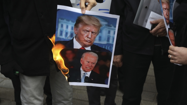 Iranian protesters burn pictures of President Trump and President-Elect Biden