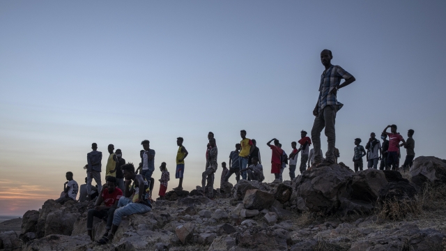Tigray people who fled the conflict in Ethiopia's Tigray region, stand on a hill