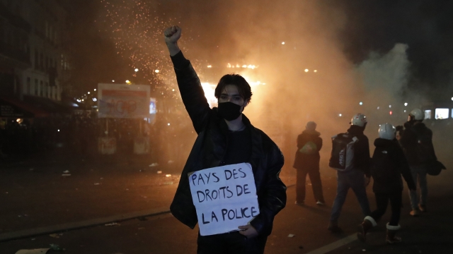 A protester in Paris holds a poster reading "Land of rights for the police" during a demonstration against a security law