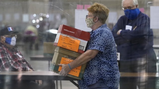 An election official brings ballots during a Milwaukee hand recount of Presidential votes at the Wisconsin Center.