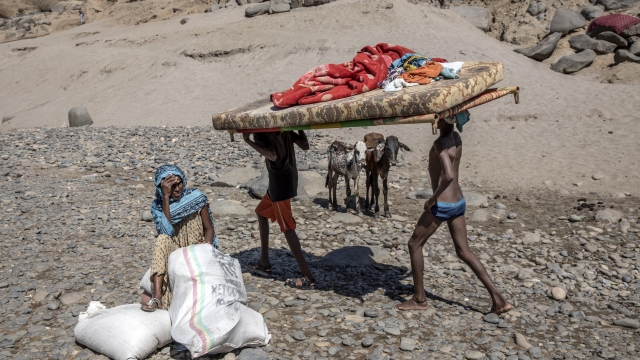 Tigray refugees who fled the conflict in the Ethiopia's Tigray carry their furniture on the banks of the Tekeze River