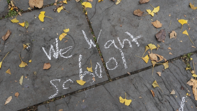 A student's graffiti is written on a sidewalk