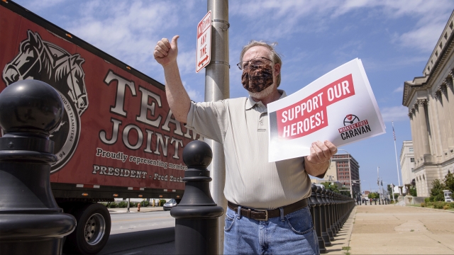 The president of the Kentucky State AFL-CIO demonstrates outside the office of Senate Majority Leader Mitch McConnell