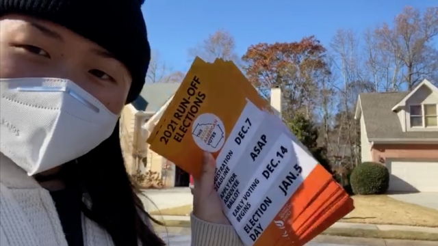 A volunteer from the Asian Americans Advancing Justice Atlanta hands out run-off election information in various languages