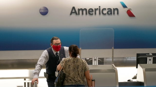 An American Airlines worker speaks with a passenger