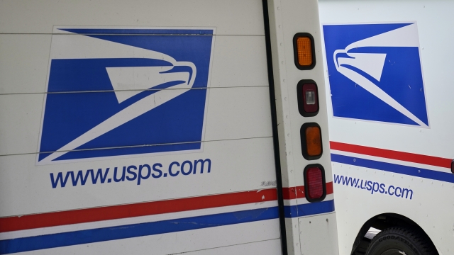 mail delivery vehicles are parked outside a post office