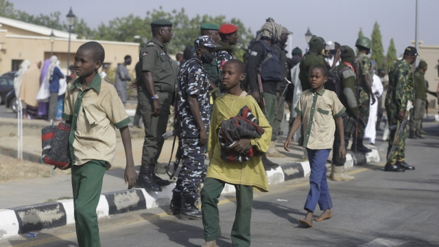 A group of schoolboys are escorted by Nigerian military and officials following their release after they were kidnapped.