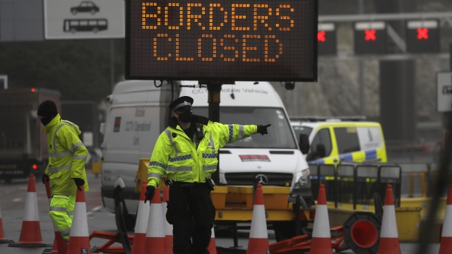 A police officer directs traffic at the entrance to the closed ferry terminal in Dover, England,
