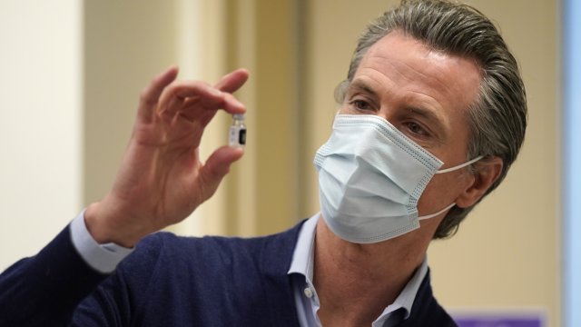 California Gov. Gavin Newsom holds up a vial of the Pfizer-BioNTech COVID-19 vaccine