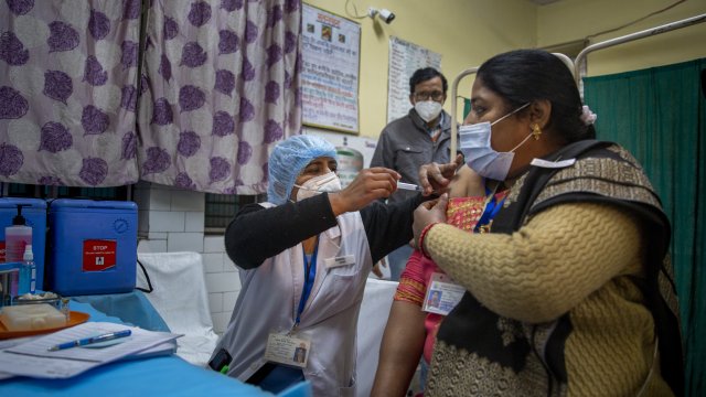 A health worker engages in a COVID-19 vaccine delivery system trial in New Delhi, India