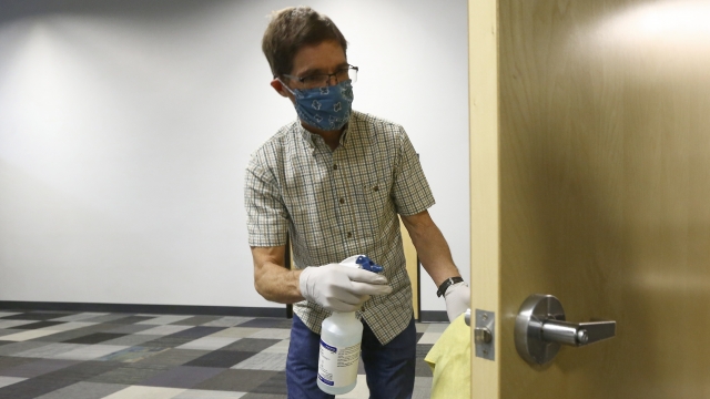 Man disinfects a door handle