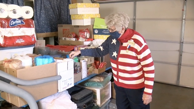 Woman packs boxes of supplies.