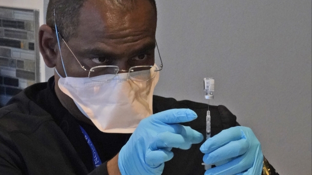 A healthcare worker fills a syringe with the COVID-19 vaccine.