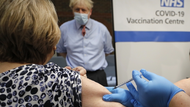 British Prime Minister Boris Johnson watches as a nurse administers the Pfizer-BioNTech COVID-19 vaccine