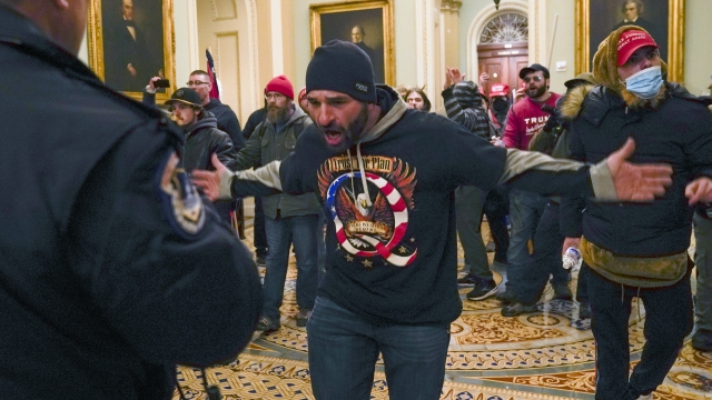 Trump supporters gesture to U.S. Capitol Police in the hallway outside of the Senate chamber at the Capitol in Washington