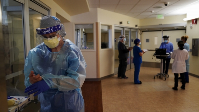 A registered nurse Merri Lynn Anderson puts on her protective equipment to check on her patient in a COVID-19 unit