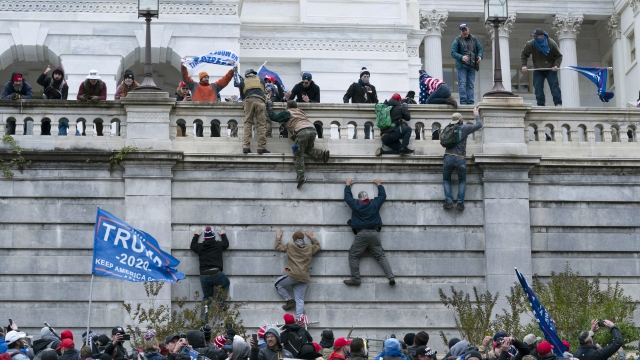 In this Wednesday, Jan. 6, 2021 file photo, supporters of President Donald Trump climb the west wall of the the U.S. Capitol