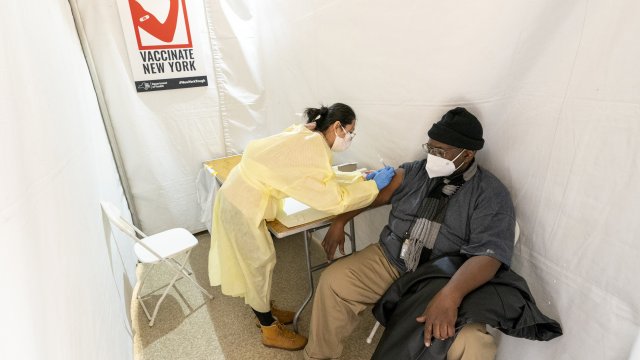 Registerd Nurse Shyun Lin, left, gives Roberto Fisher, 72, the first dose of the COVID-19 vaccine