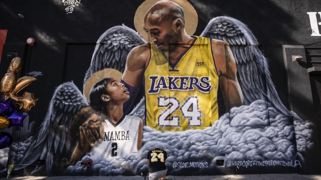 Adam Dergazarian, bottom center, pays his respect for Kobe Bryant and his daughter, Gianna, in front of a mural.