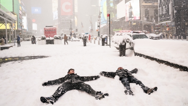 People make snow angels during a snowstorm in Times Square
