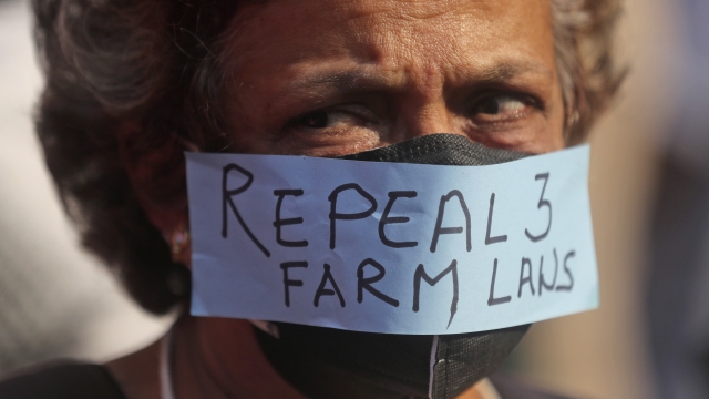Woman in Indian farmers' protest posts demands on her mask.