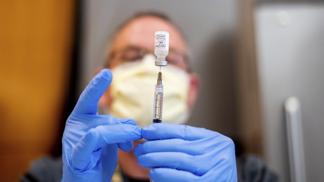 A pharmacist draws saline while preparing a dose of Pfizer's COVID-19 vaccine