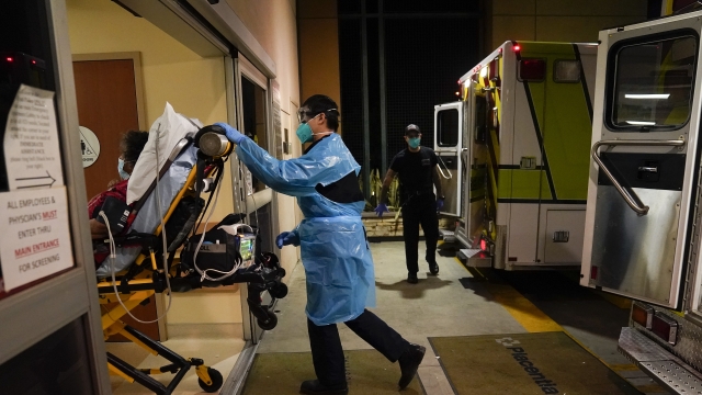 An EMT pushes a gurney into an emergency room to drop off a COVID-19 patient in Placentia, Calif.