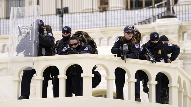 Officials keep watch as President Donald Trump supporters try to break through a police barrier, Wednesday, Jan. 6, 2021.