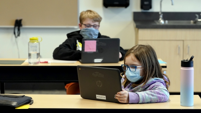 Students wear masks as they work in a fourth-grade classroom