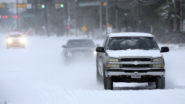 Vehicles drive on snow and sleet covered roads