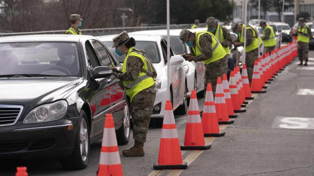 Members of the National Guard help motorists check in at a federally-run COVID-19 vaccination site.