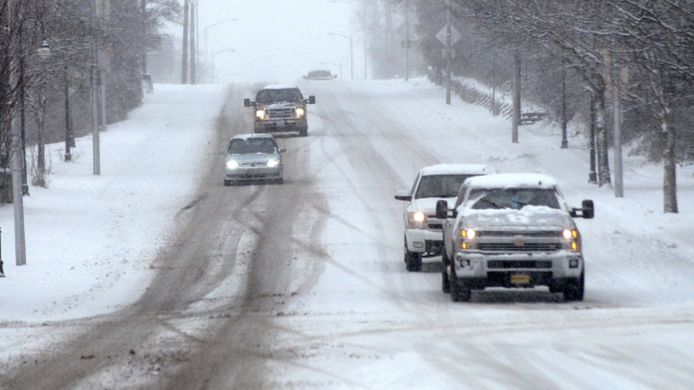 Traffic makes its way down a snow-covered stretch of East Front Street