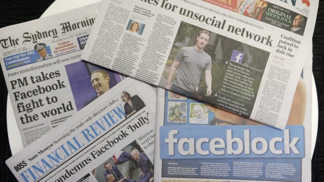 Front pages of Australian newspapers are displayed featuring stories about Facebook in Sydney.