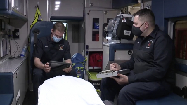 Men sit in an ambulance.