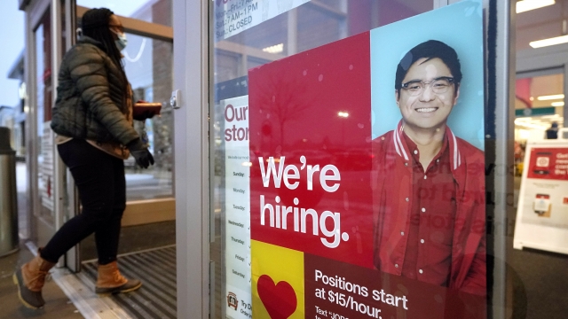 A passer-by walks past an employment hiring sign while entering a Target store location, in Westwood, Mass.