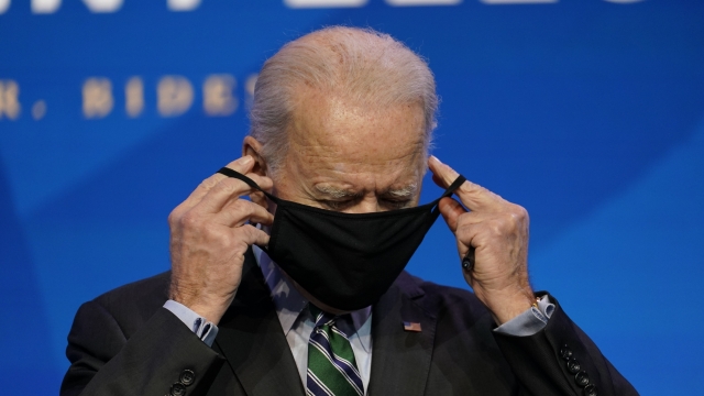 President Joe Biden puts on his face mask