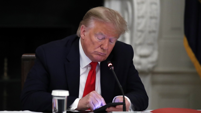 Former President Donald Trump looks at his phone.