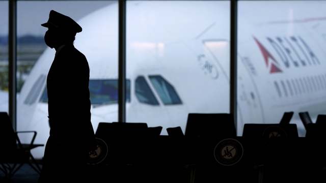 A pilot walks past a parked Delta Air Lines plane
