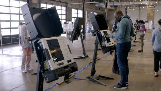 Voters use electronic machine to fill out ballot.