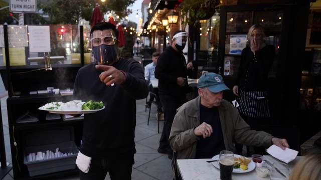 A server carries food at a restaurant in California.