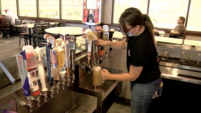Woman pours a beer.