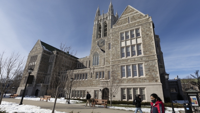 In this Feb. 17, 2021, file photo, students walk on the Boston College campus.