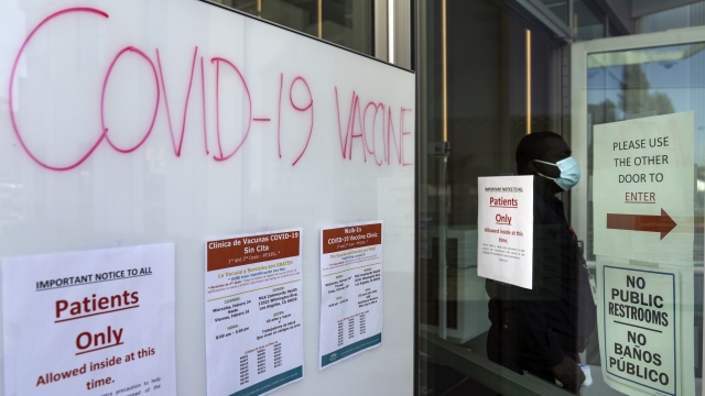 A COVID-19 vaccine sign posted on the doors of the MLK Community Medical Group clinic in Los Angeles.