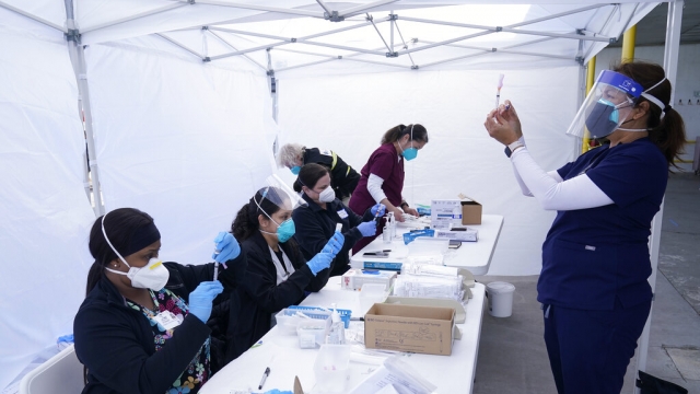 Health care workers prepare the Moderna COVID-19 vaccines.