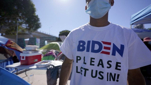 Man seeking asylum in the U.S. wearing a shirt that reads, "Biden please let us in."