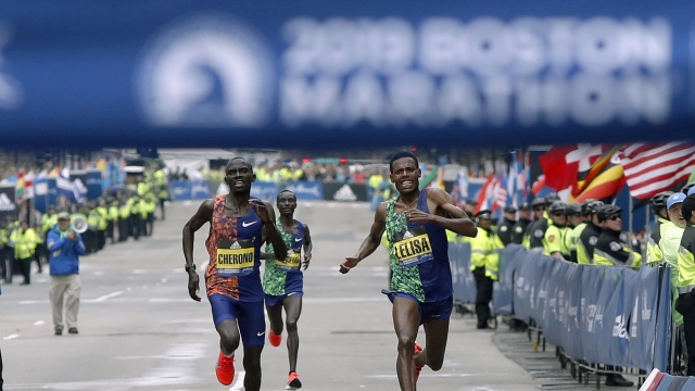 Lawrence Cherono, left, of Kenya, runs to the finish line to win the 123rd Boston Marathon.