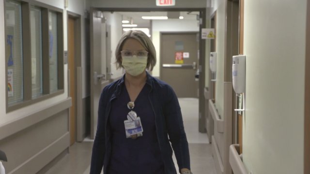 Nurse walks down a hallway.