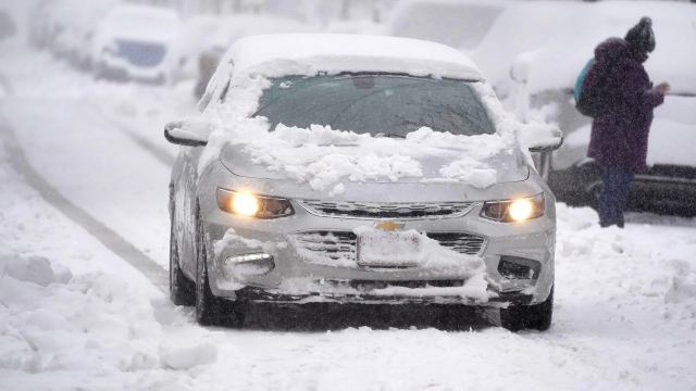 Car drives through snowy Denver street