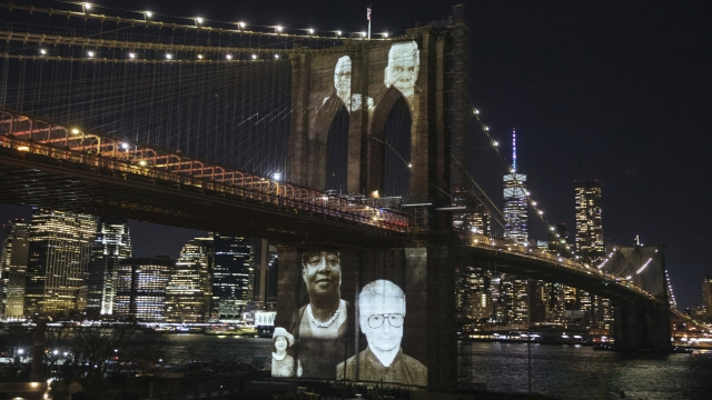 New Yorkers who passed during the Covid-19 pandemic are projected onto the Brooklyn Bridge during a commemoration ceremony.